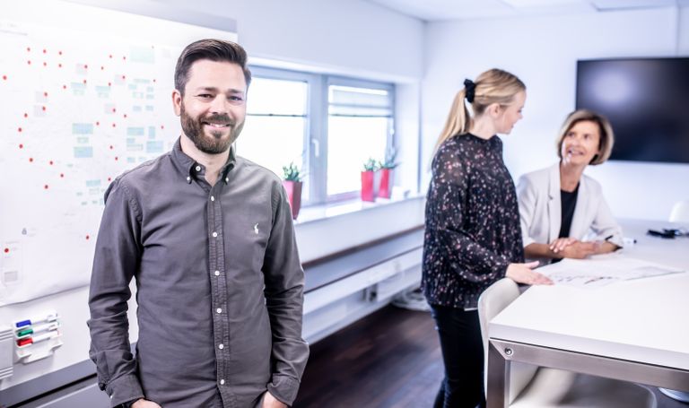 Smiling team meeting in office space with collaborative atmosphere and modern interior.