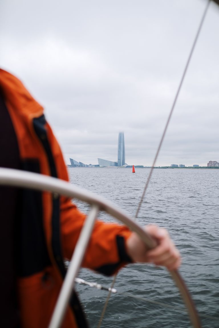 Segler steuert Boot vor Skyline.